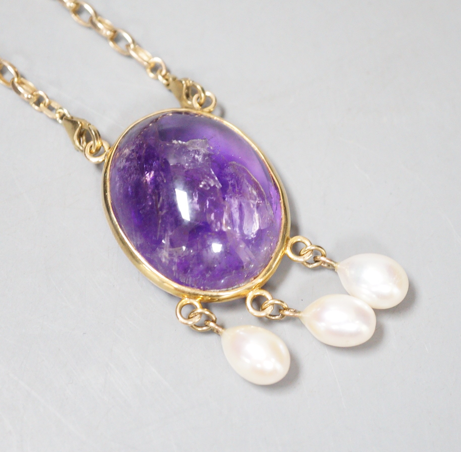 A modern 375 yellow metal mounted cabochon amethyst and three stone culture pearl set drop pendant, 58mm, on a 375 chain, 46cm, gross weight 37.8 grams.